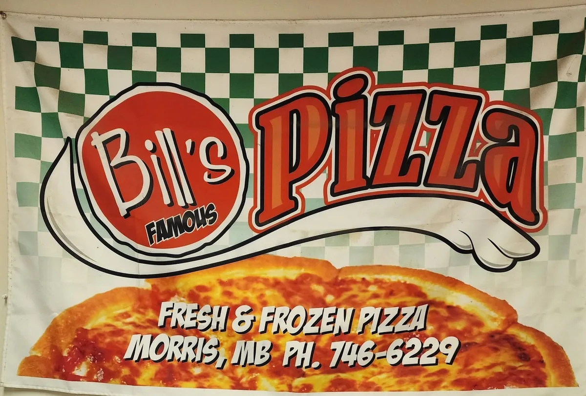 Bill's Famous Pizza banner with green checkers reading Fresh and Frozen Pizza, Morris MB